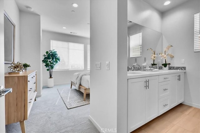 bathroom featuring recessed lighting, baseboards, vanity, and ensuite bath