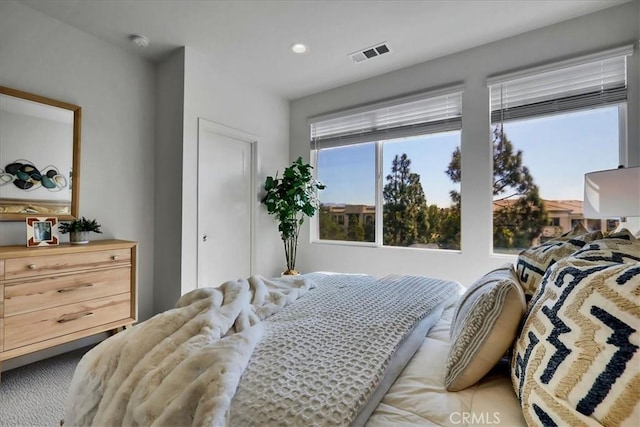 bedroom with light carpet, visible vents, and recessed lighting