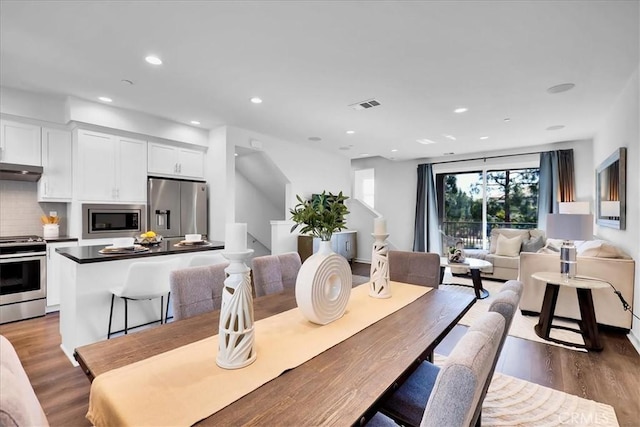 dining area with dark wood-style flooring, visible vents, and recessed lighting