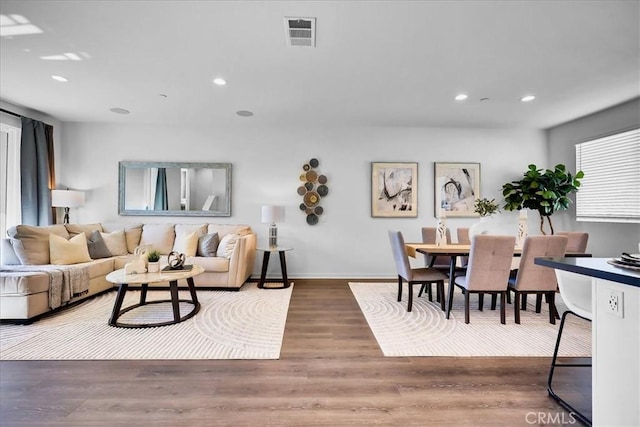 living area featuring recessed lighting, visible vents, baseboards, and wood finished floors