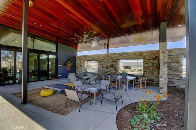 view of patio with outdoor dining space, ceiling fan, and an outdoor fire pit