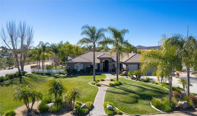 view of front of house featuring a front yard, a tiled roof, and an attached garage