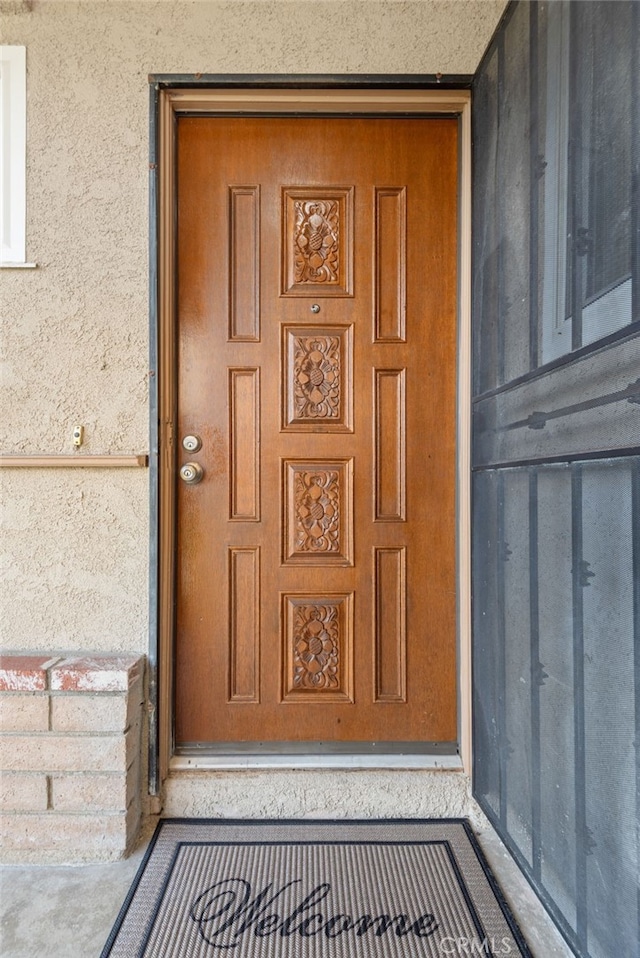 entrance to property featuring stucco siding