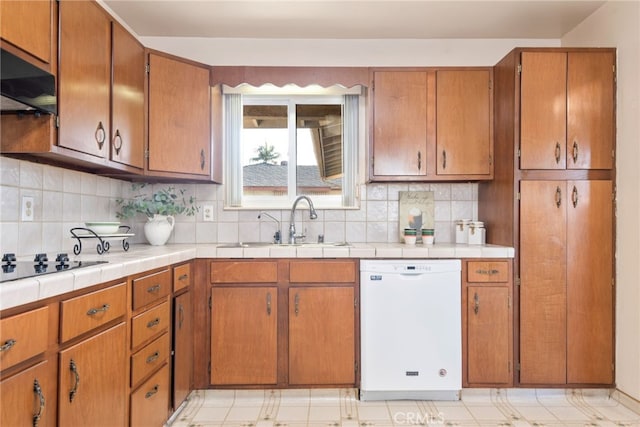 kitchen featuring a sink, brown cabinets, black electric cooktop, and dishwasher