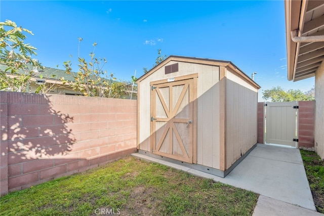 view of shed featuring a fenced backyard and a gate