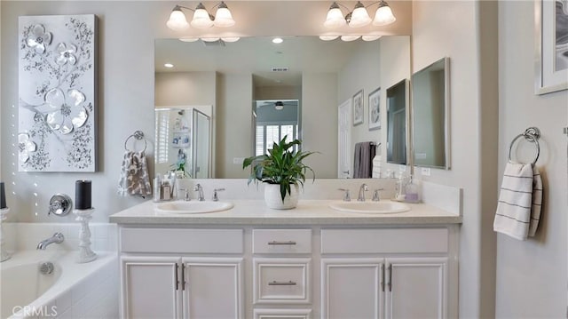 bathroom featuring double vanity, a sink, a shower stall, and a bath