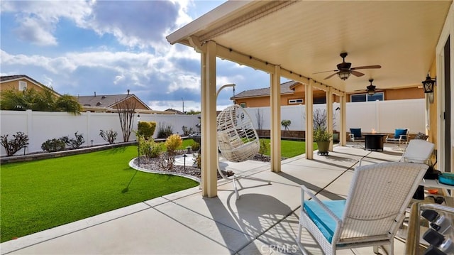 view of patio with a fenced backyard, a fire pit, and a ceiling fan