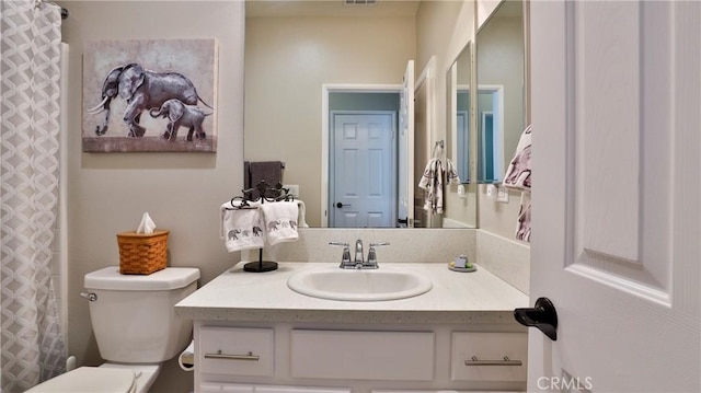 bathroom featuring toilet, curtained shower, visible vents, and vanity