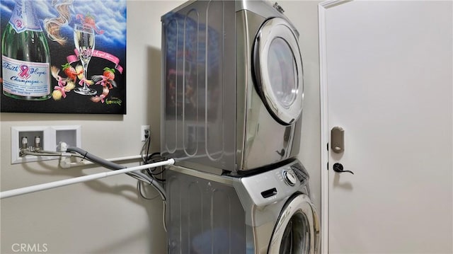 laundry area with stacked washer / drying machine and laundry area