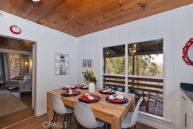 dining space featuring dark wood-style flooring and wooden ceiling