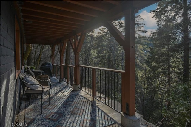 wooden terrace featuring a forest view