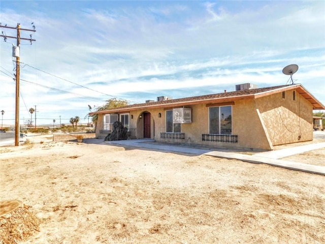 ranch-style house featuring a patio area, cooling unit, and stucco siding