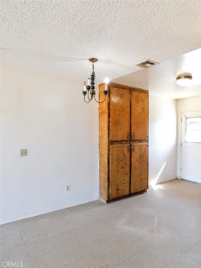 spare room with visible vents and a textured ceiling