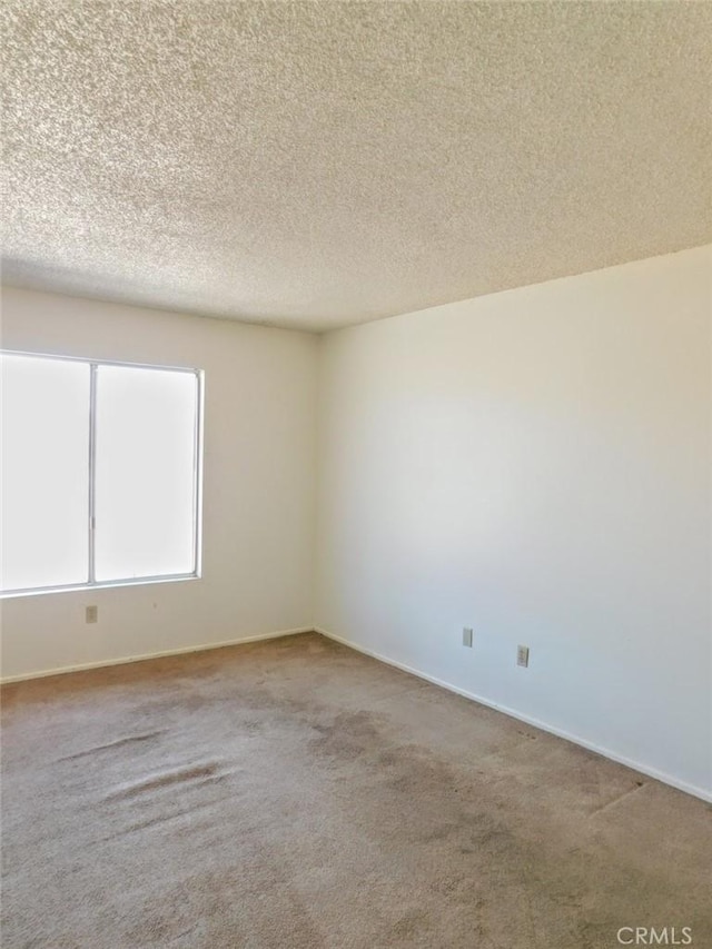 carpeted spare room featuring a textured ceiling