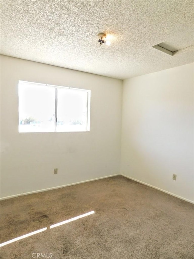 empty room featuring a textured ceiling, baseboards, and carpet flooring