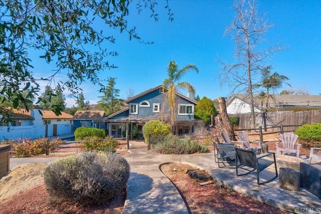 exterior space featuring a fire pit, stucco siding, fence, and a patio