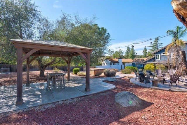 view of yard featuring a fire pit, a gazebo, a patio, and fence