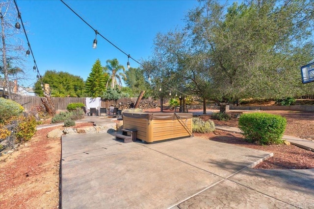 view of patio / terrace featuring a fenced backyard and a hot tub