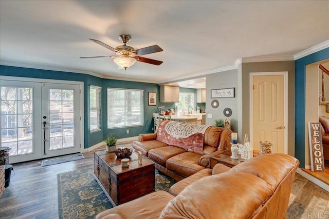 living area with wood finished floors, a ceiling fan, baseboards, french doors, and crown molding