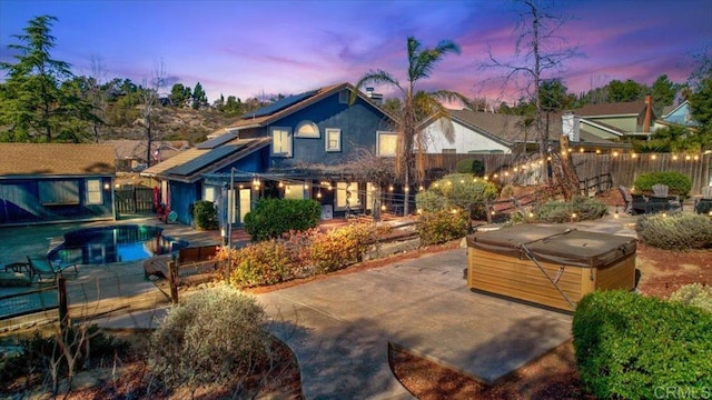 exterior space with a patio, a hot tub, a fenced backyard, an outdoor structure, and a swimming pool