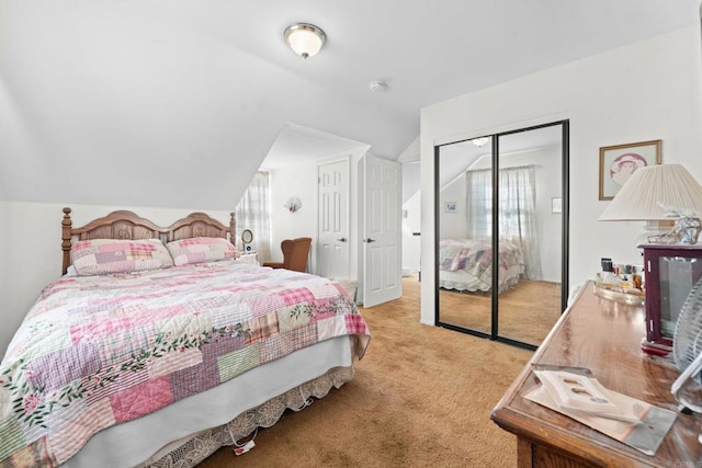 bedroom with lofted ceiling, a closet, and light colored carpet