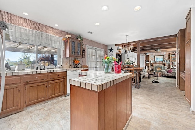 kitchen featuring tile countertops, visible vents, glass insert cabinets, brown cabinetry, and white dishwasher