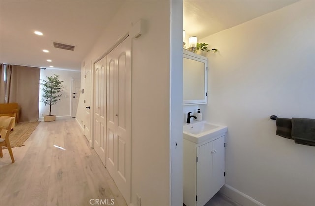 bathroom featuring visible vents, baseboards, recessed lighting, wood finished floors, and vanity