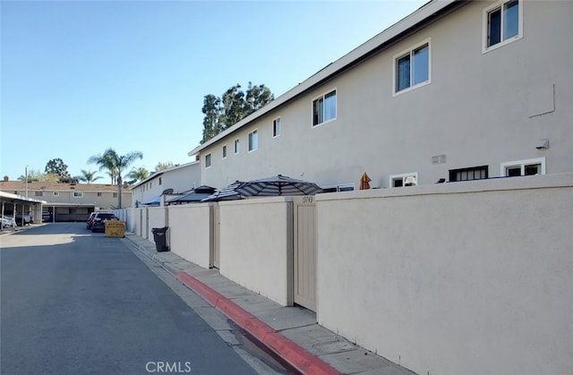 view of home's exterior with stucco siding and fence