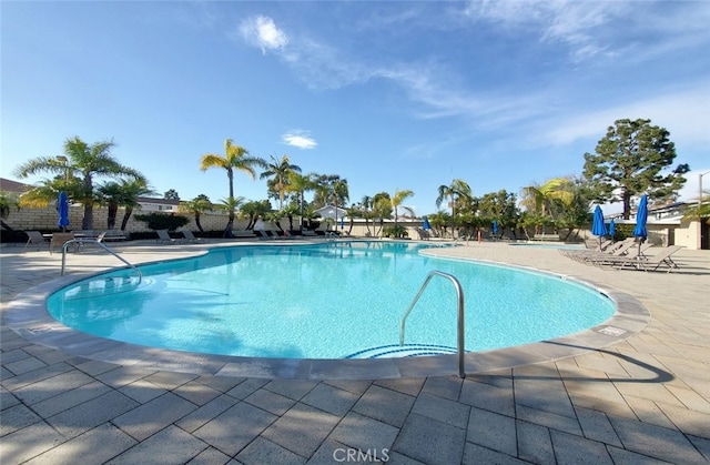 community pool featuring a patio and fence