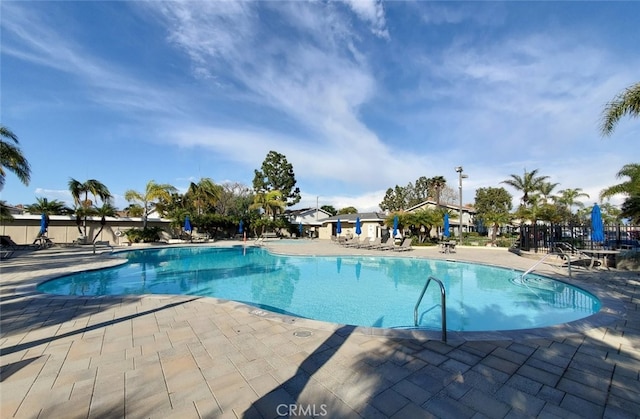 community pool featuring a patio and fence