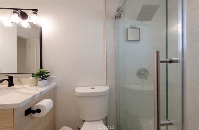 bathroom featuring vanity, toilet, and a shower stall