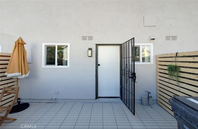 entrance to property featuring visible vents and stucco siding