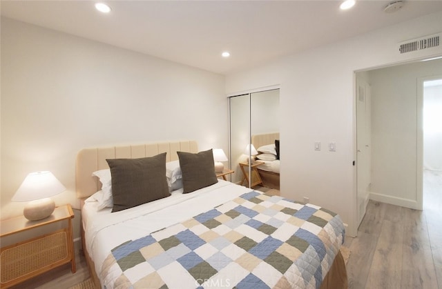 bedroom with visible vents, baseboards, light wood-type flooring, recessed lighting, and a closet