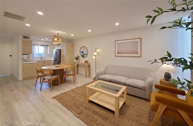 living area featuring recessed lighting, visible vents, and light wood finished floors