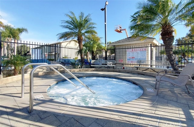 view of pool featuring fence and a hot tub