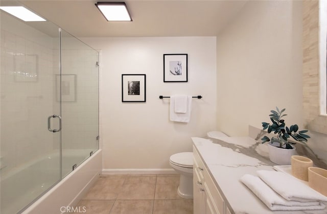 full bathroom with vanity, toilet, tile patterned floors, baseboards, and combined bath / shower with glass door
