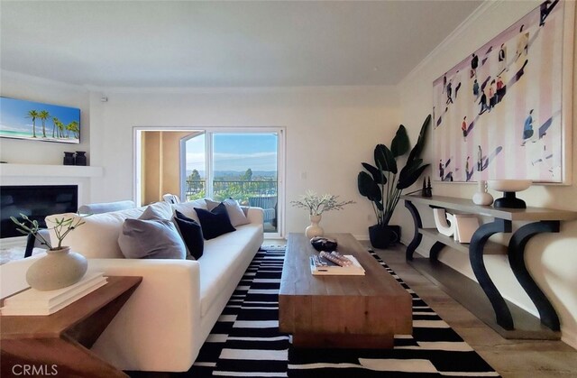 living room with crown molding, a glass covered fireplace, and wood finished floors