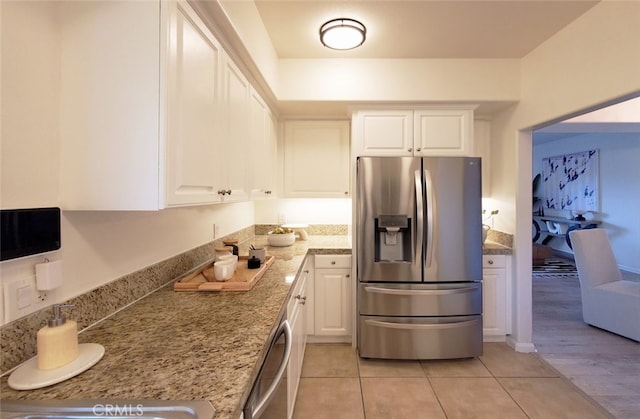 kitchen with light stone counters, white cabinetry, light tile patterned floors, and stainless steel appliances