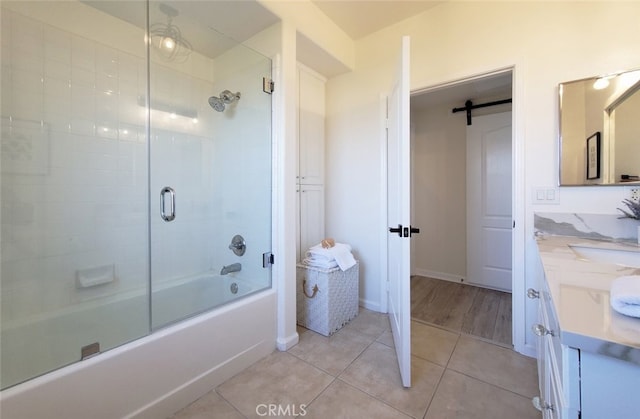 bathroom with tile patterned flooring, enclosed tub / shower combo, and vanity
