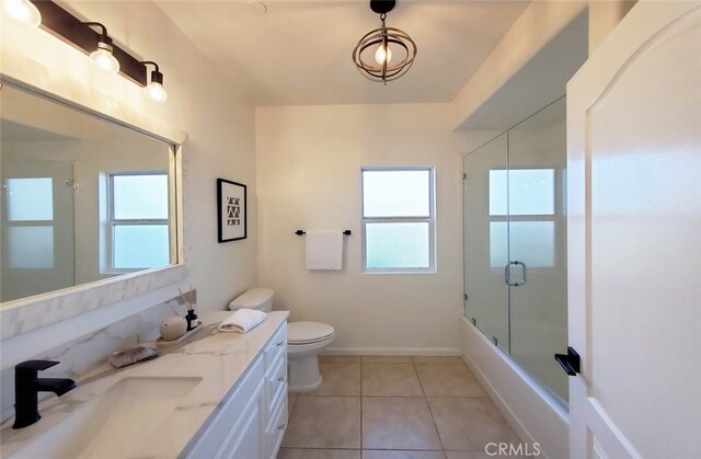 full bathroom with tile patterned flooring, a healthy amount of sunlight, toilet, and vanity