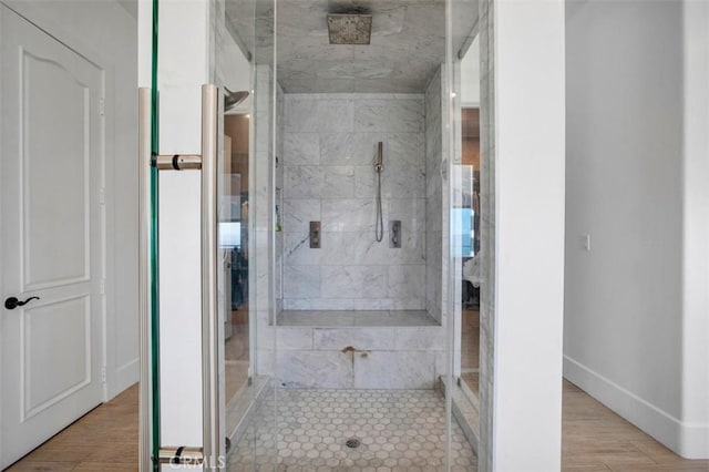 full bathroom featuring a stall shower, baseboards, and wood finished floors