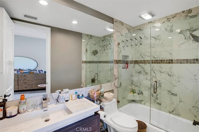 bathroom featuring toilet, shower / bath combination with glass door, vanity, and visible vents