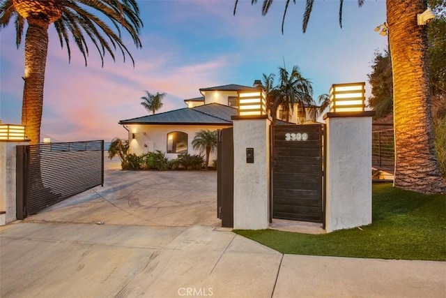 view of front of home featuring a gate, fence, and stucco siding