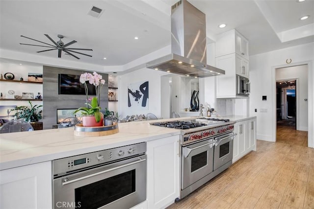 kitchen with white cabinets, island exhaust hood, and stainless steel appliances