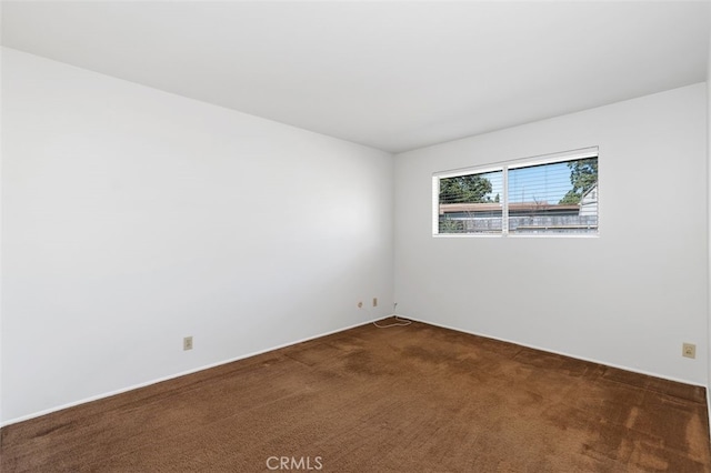 spare room with dark carpet