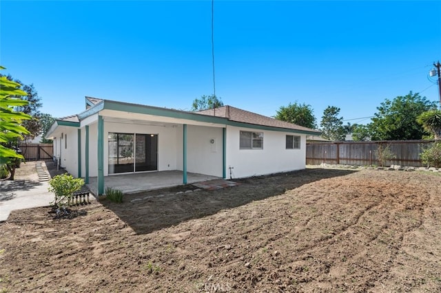 rear view of house featuring a fenced backyard and a patio