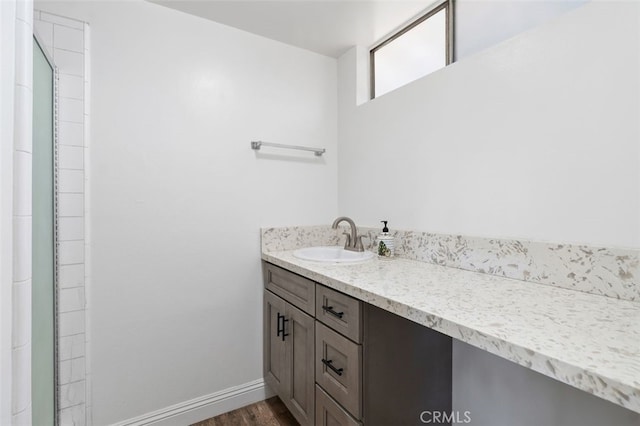 bathroom featuring wood finished floors, vanity, and baseboards