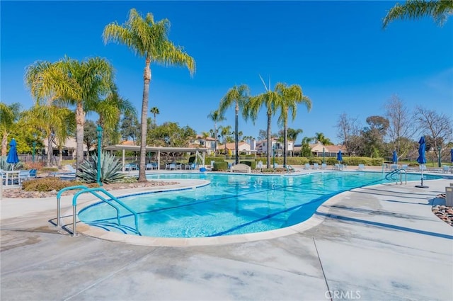 community pool with a patio and fence