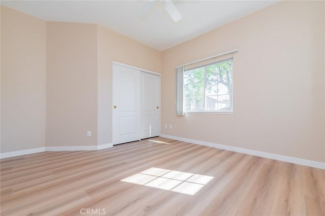 unfurnished bedroom with a closet, a ceiling fan, baseboards, and wood finished floors