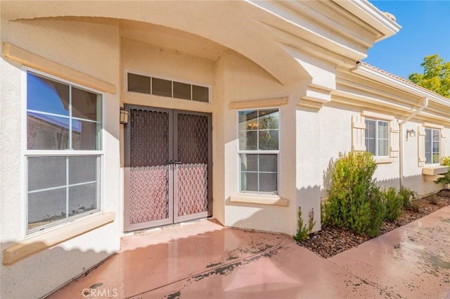 entrance to property featuring stucco siding